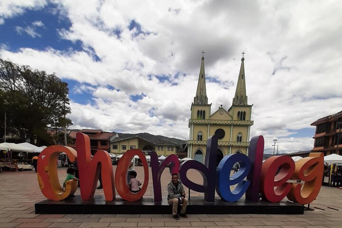 a man sitting in front of a large sign that says peace