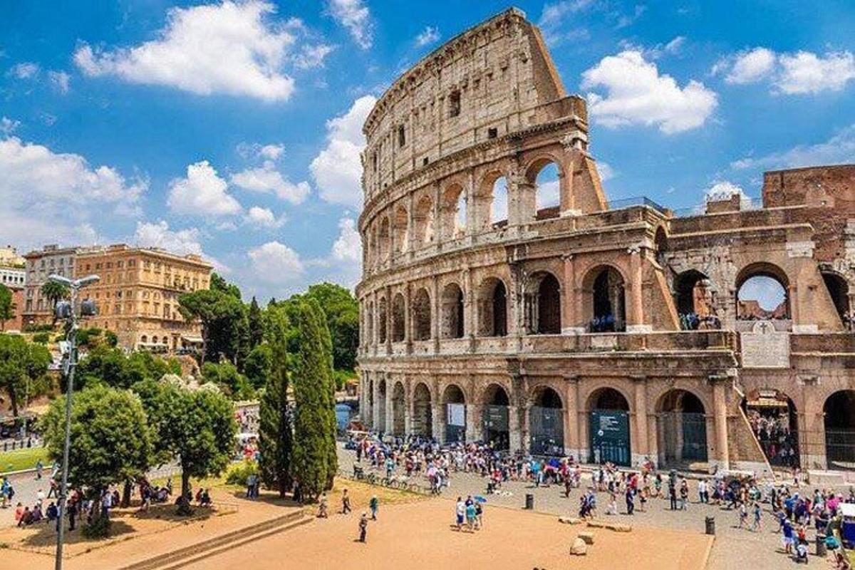 a group of people standing in front of the coliseum