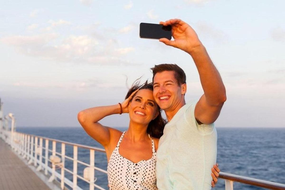 un uomo e una donna che scattano una foto su una nave da crociera