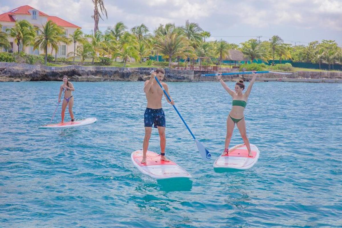 tatlong tao ang nasa paddle board sa tubig