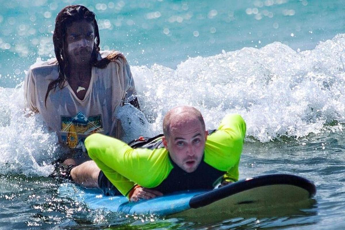en kvinne og en mann på et surfebrett i vannet