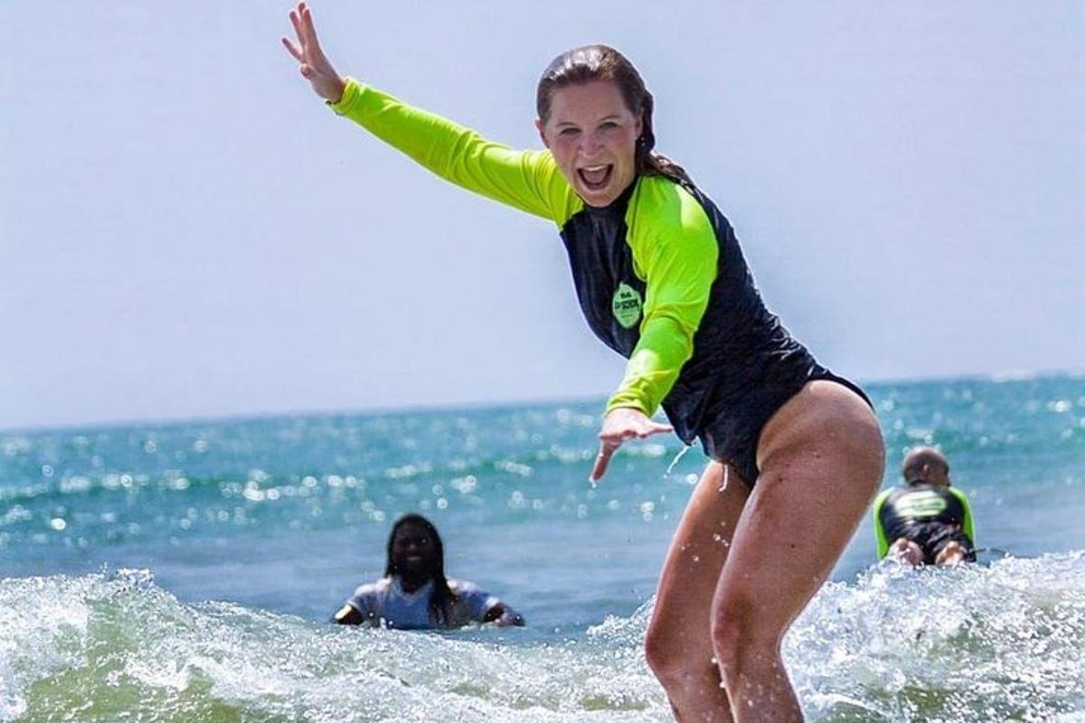en kvinne som rir på en bølge på et surfebrett i havet