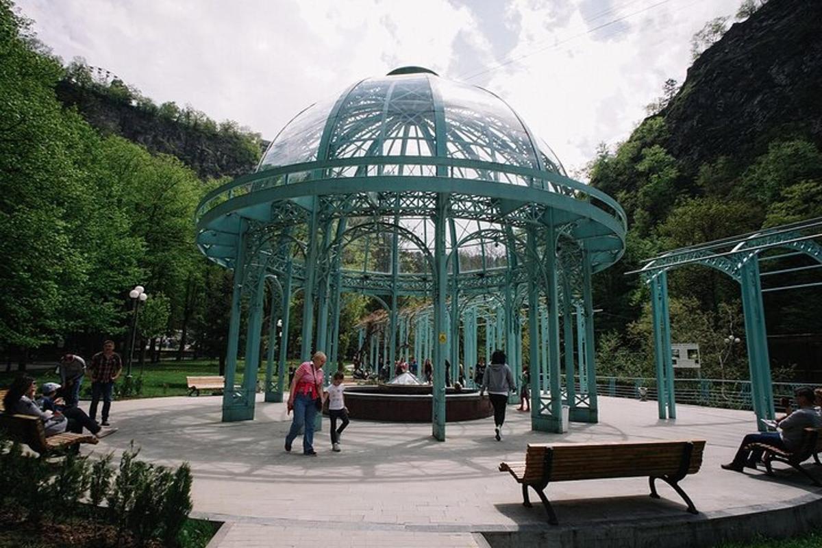 een groene structuur met een fontein in een park