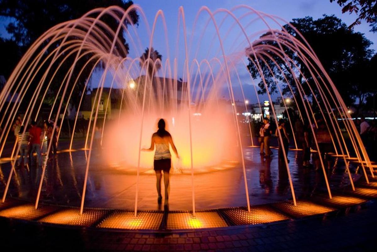 a woman standing in front of a fountain