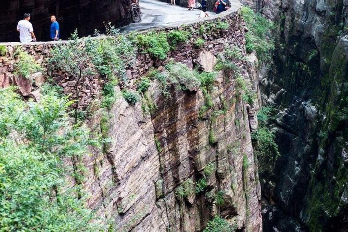 people walking on the side of a mountain