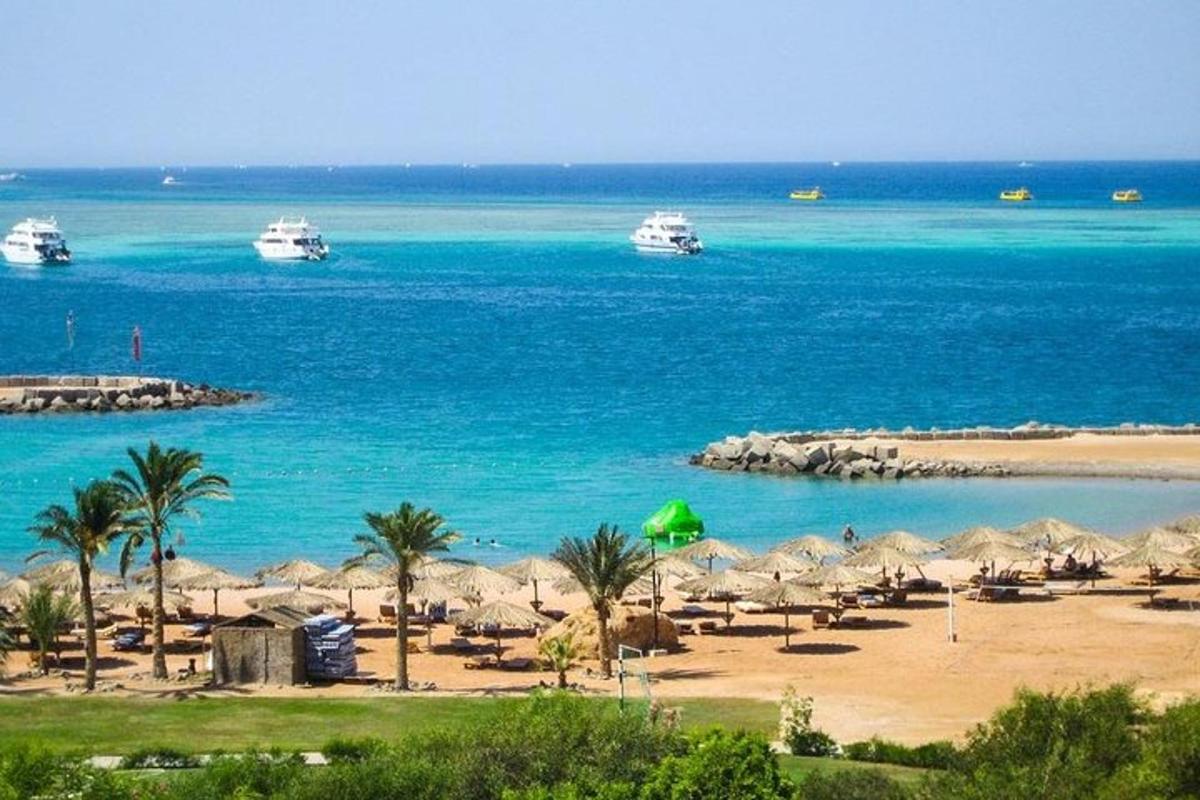 a beach with boats in the water and palm trees