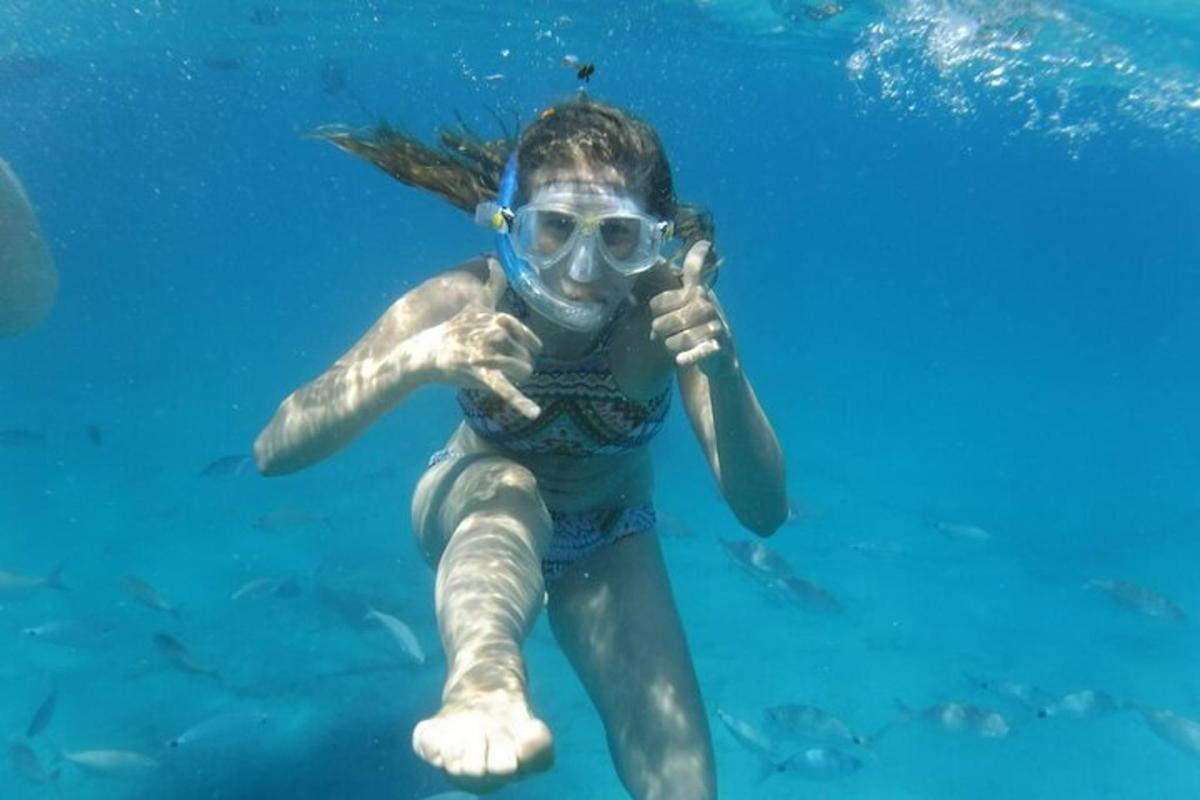 isang batang babae sa isang snorkel at salaming de kolor sa tubig