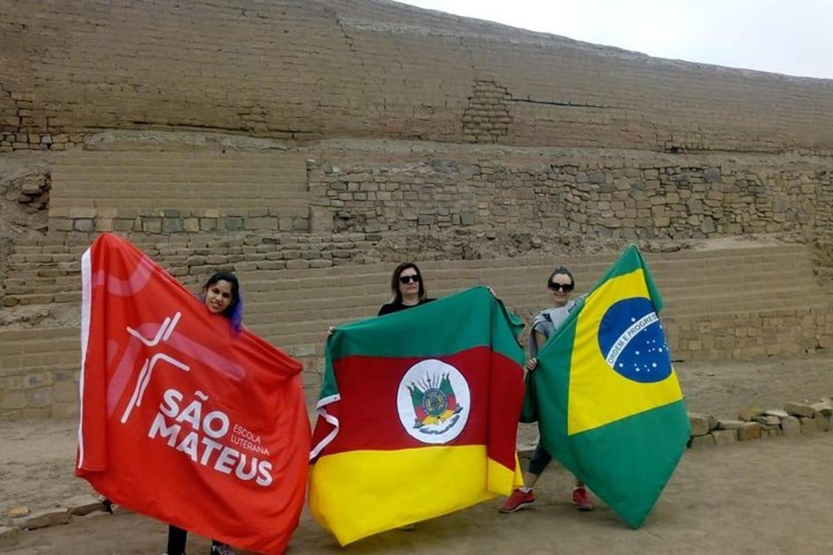 a group of three people holding flags in front ofartifacts