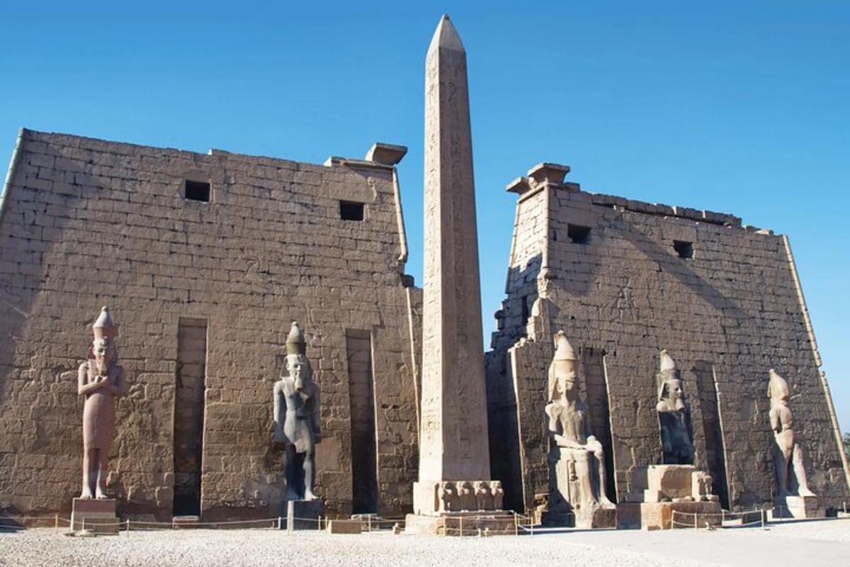 un edificio con estatuas de mujeres y un obelisco