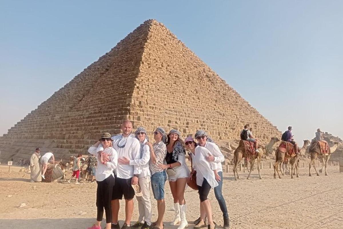 un gruppo di persone in piedi davanti a una piramide