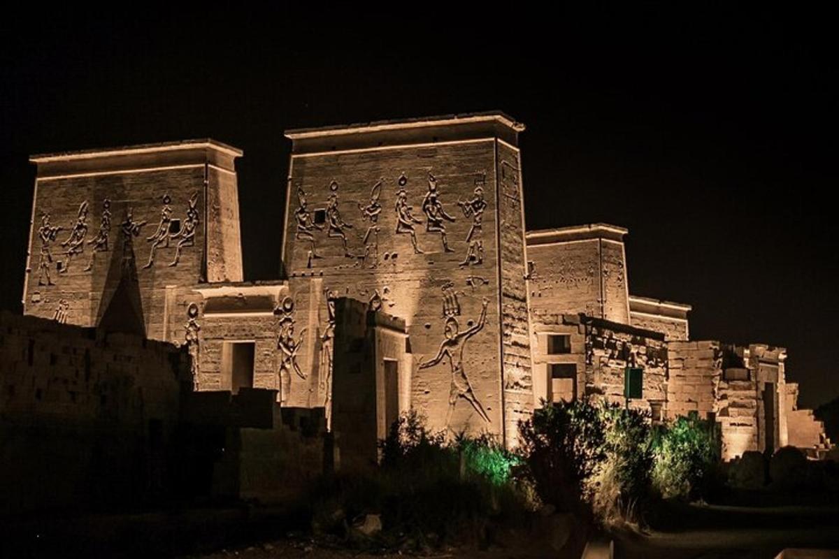 Un edificio de piedra con escritura en él por la noche.