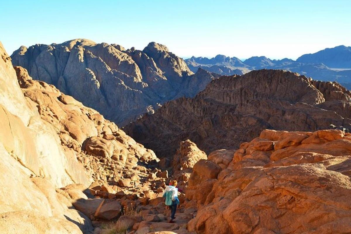 una persona che cammina su un sentiero roccioso attraverso un canyon