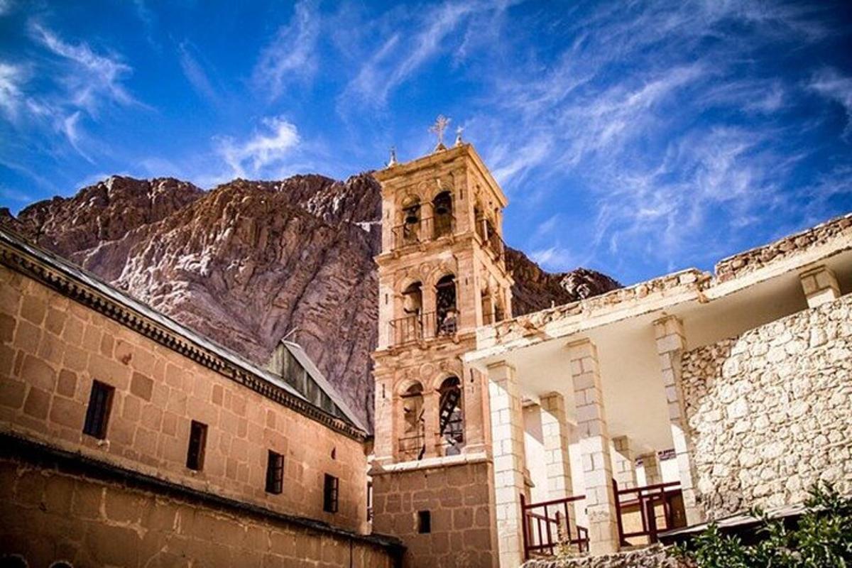 un edificio con una torre dell'orologio di fronte a una montagna