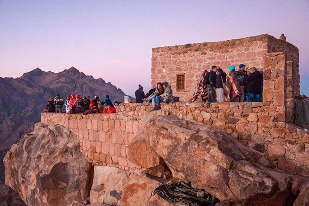 un gruppo di persone in piedi in cima a un muro di mattoni