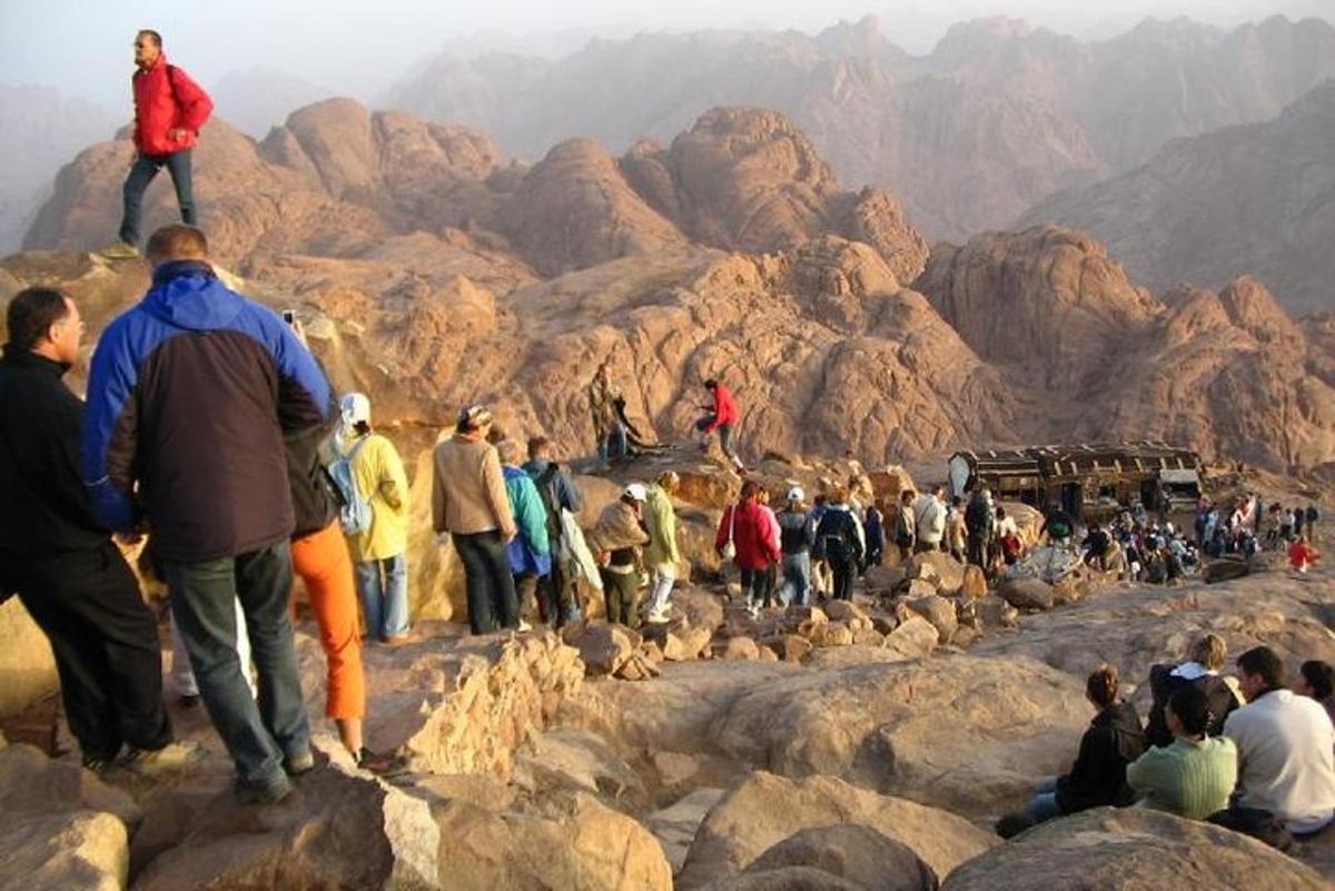 una folla di persone in piedi sulle rocce di una montagna