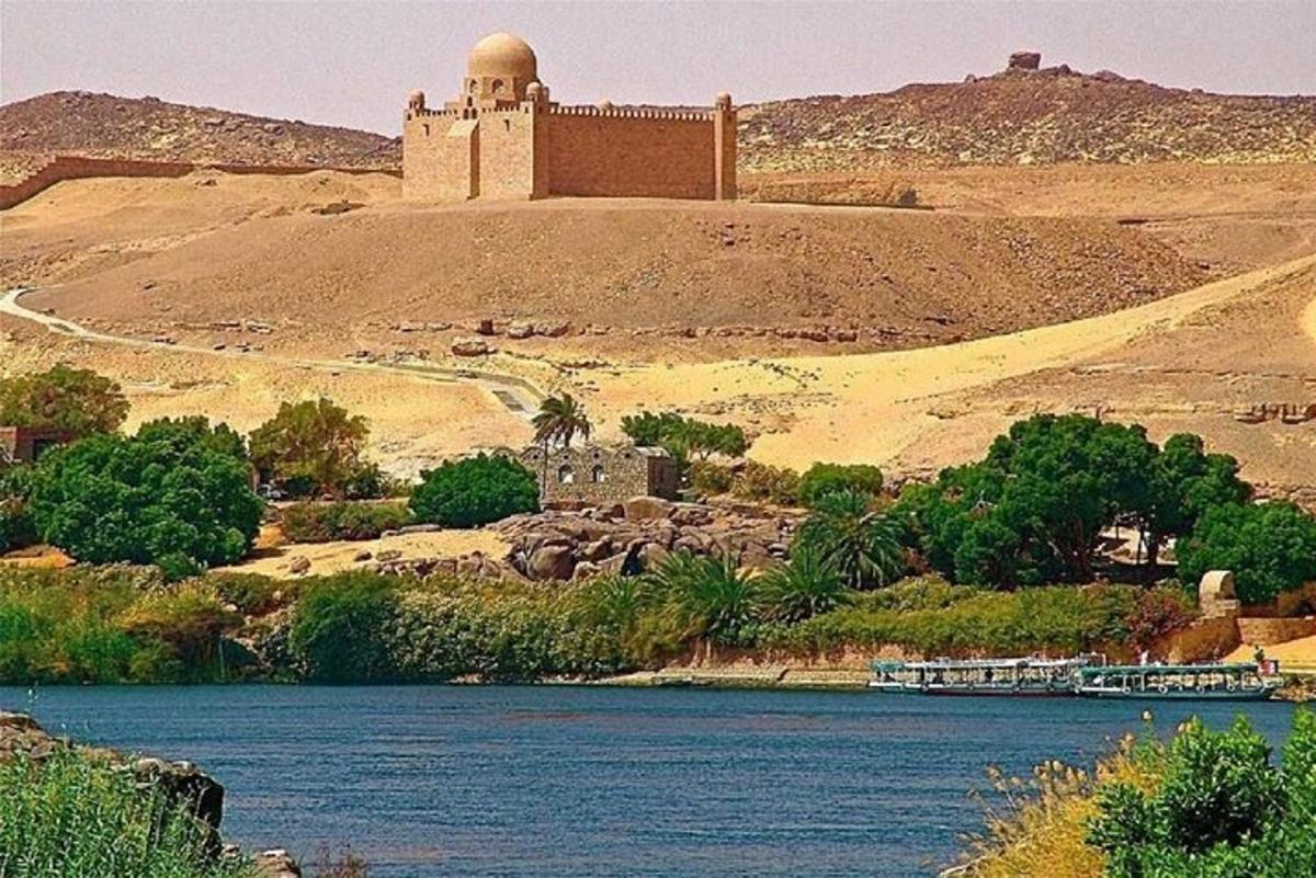 a building on a hill next to a body of water