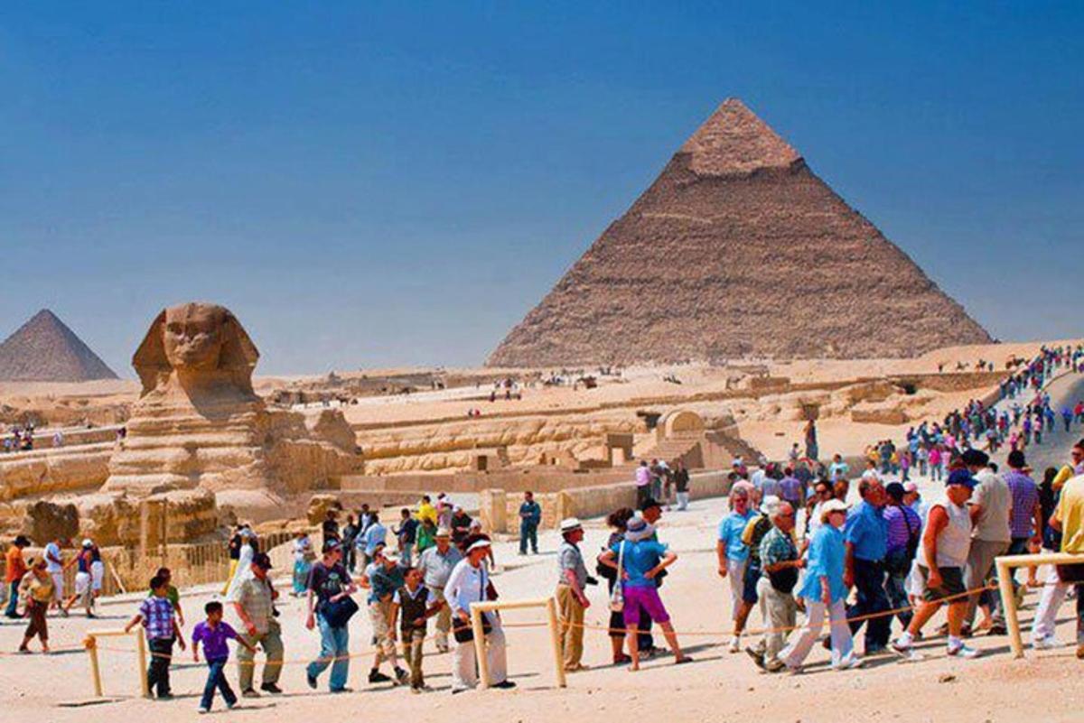 skupina lidí stojící před pyramidami