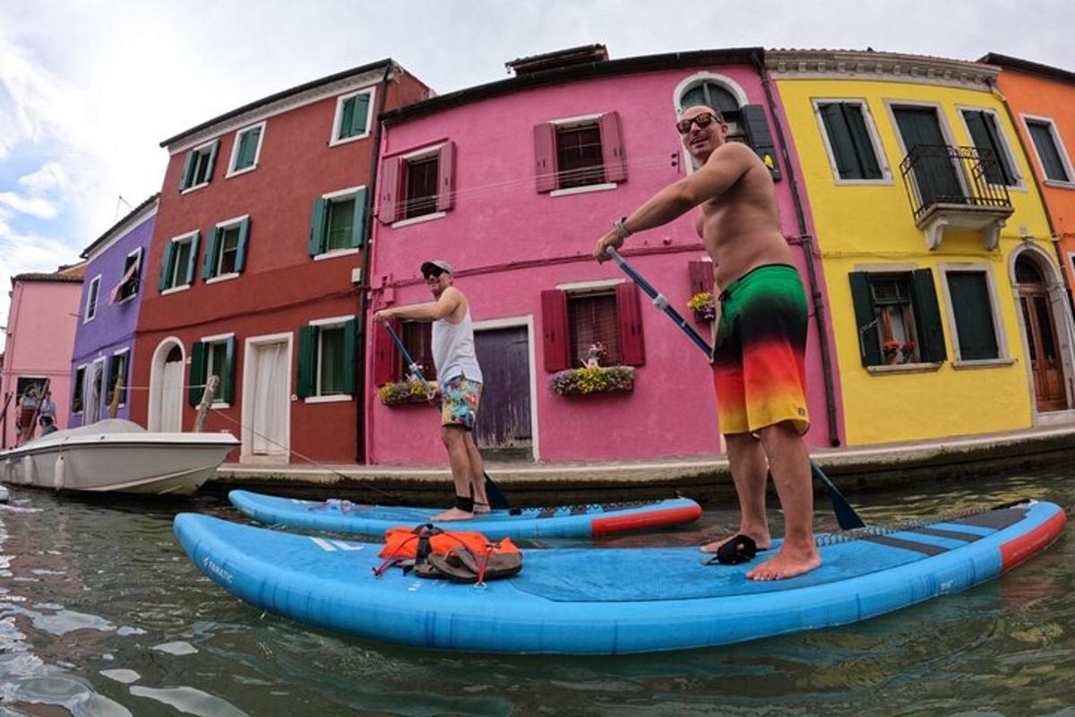 Dva muži stojí na paddleboardech ve vodě