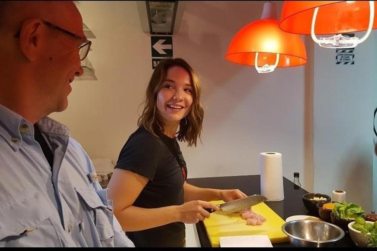 un uomo e una donna in piedi in una cucina che preparano il cibo