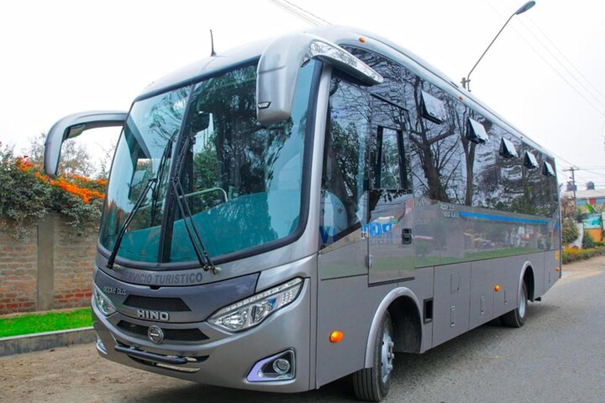 a silver bus parked on the side of the road