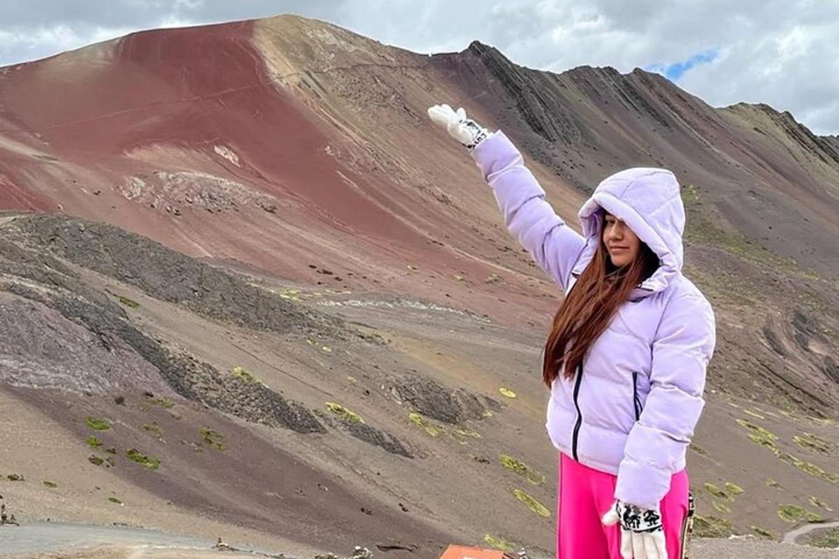 una donna in piedi su una collina con la mano alzata in aria