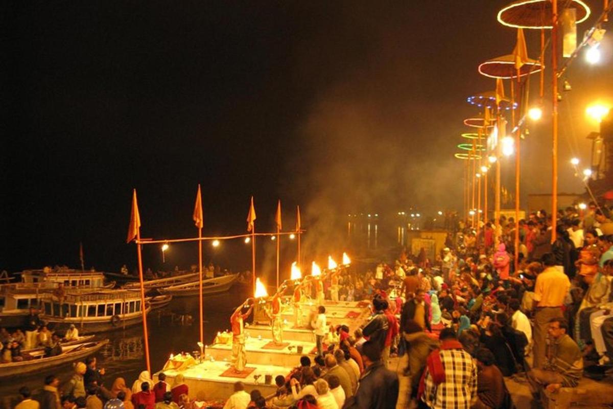 a crowd of people standing on a pier at night