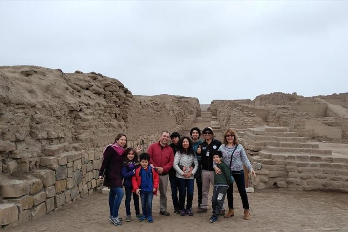 Un grupo de personas de pie frente a una ruina.