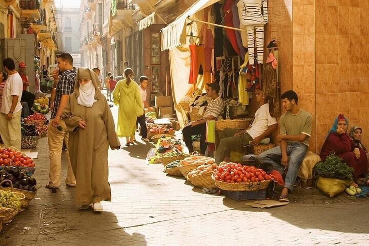 a group of people walking down a street in a market