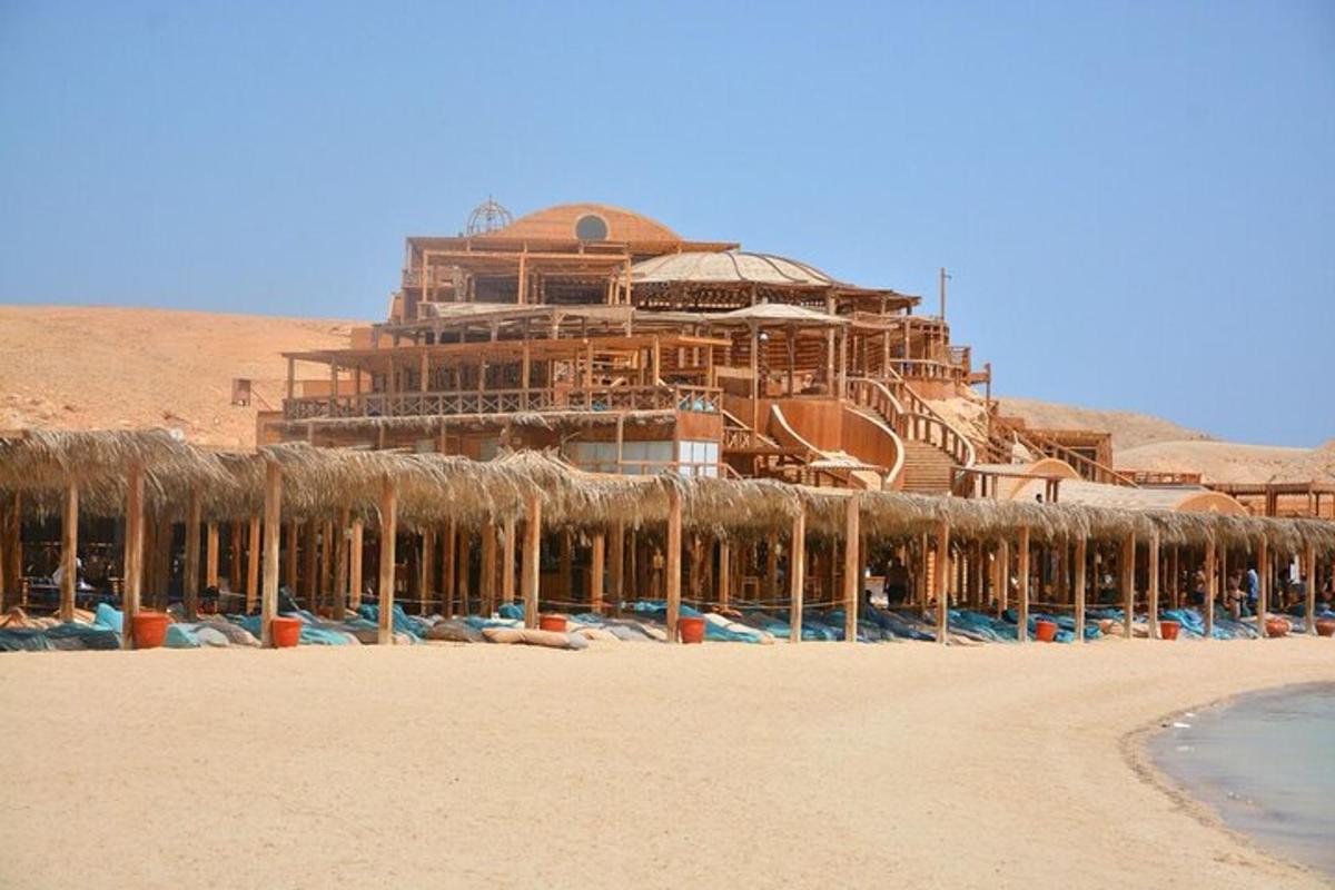 Un gran edificio en una playa con un edificio al fondo.