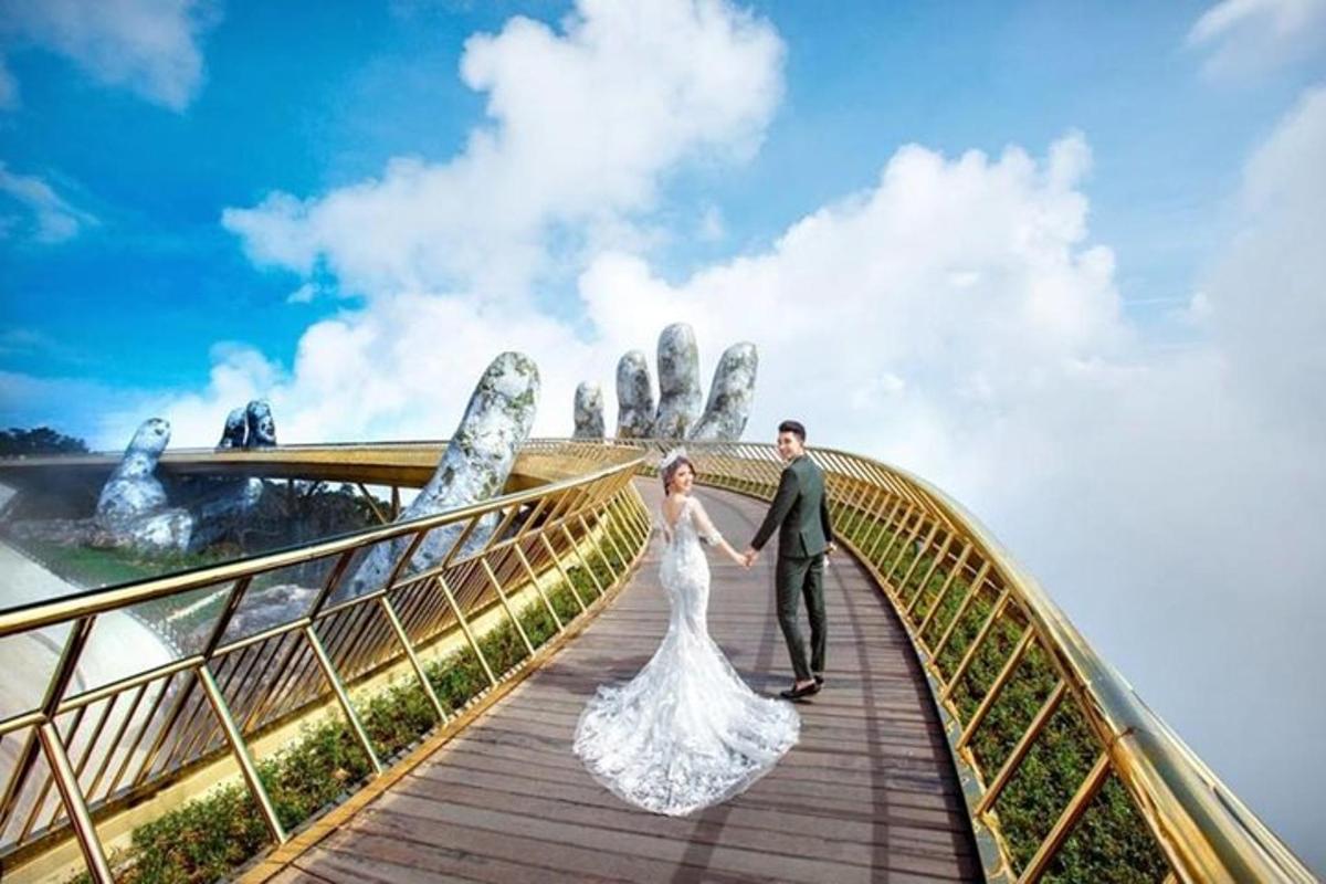 pasangan pengantin berdiri di atas jambatan