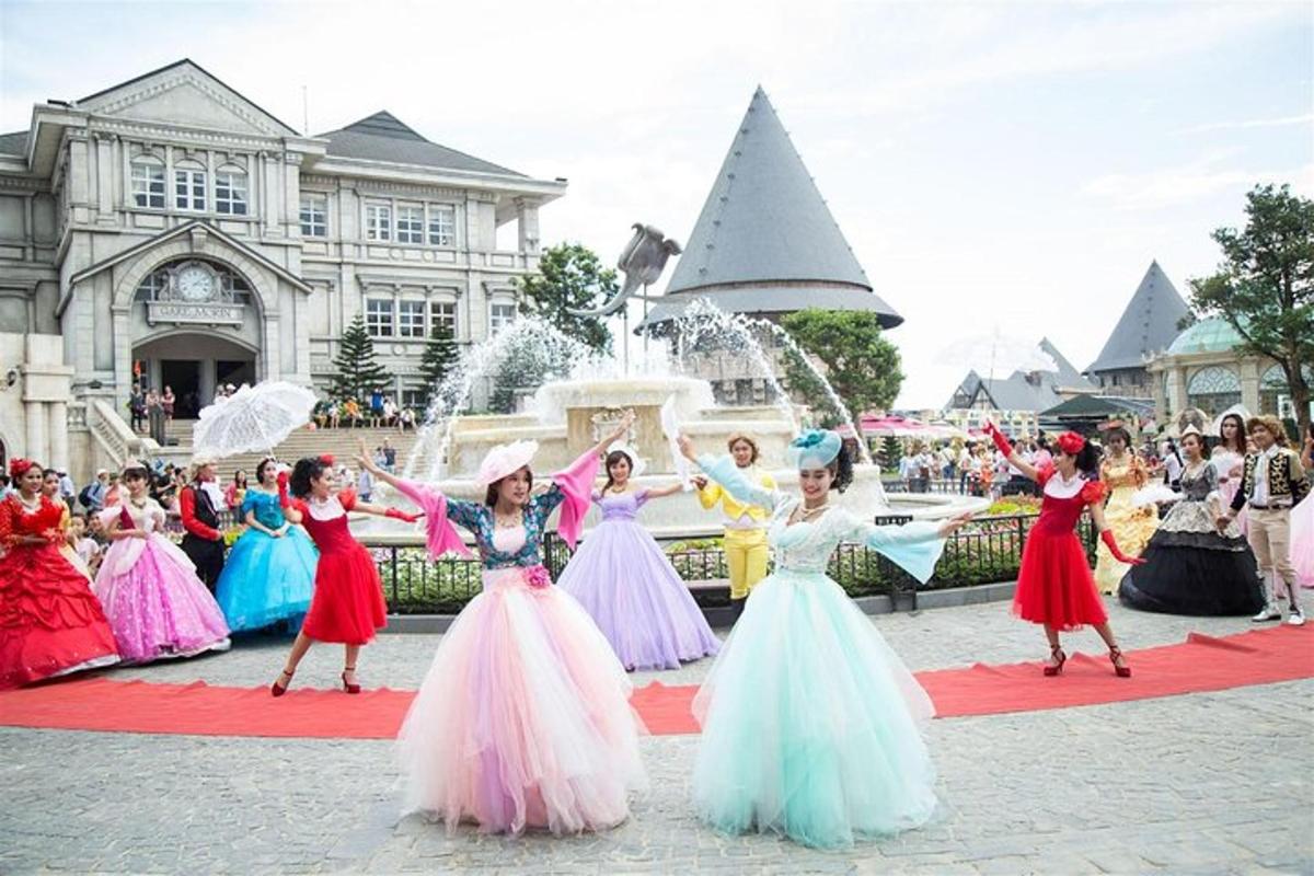 sekumpulan gadis berpakaian berwarna-warni menari di hadapan air pancut