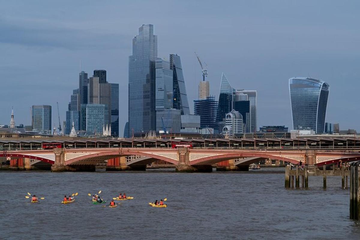 un grup de persones en caiacs a l'aigua prop d'un pont