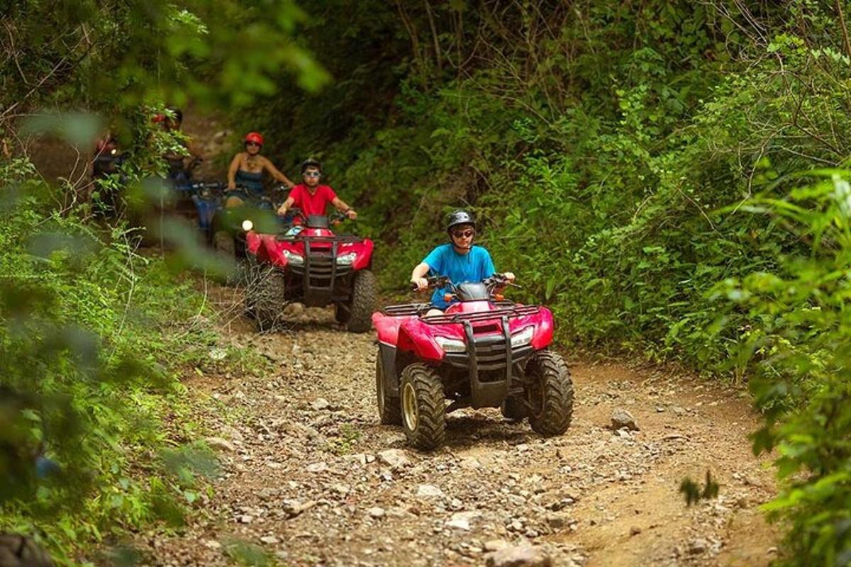isang grupo ng mga tao na nakasakay sa mga atv sa isang dirt trail