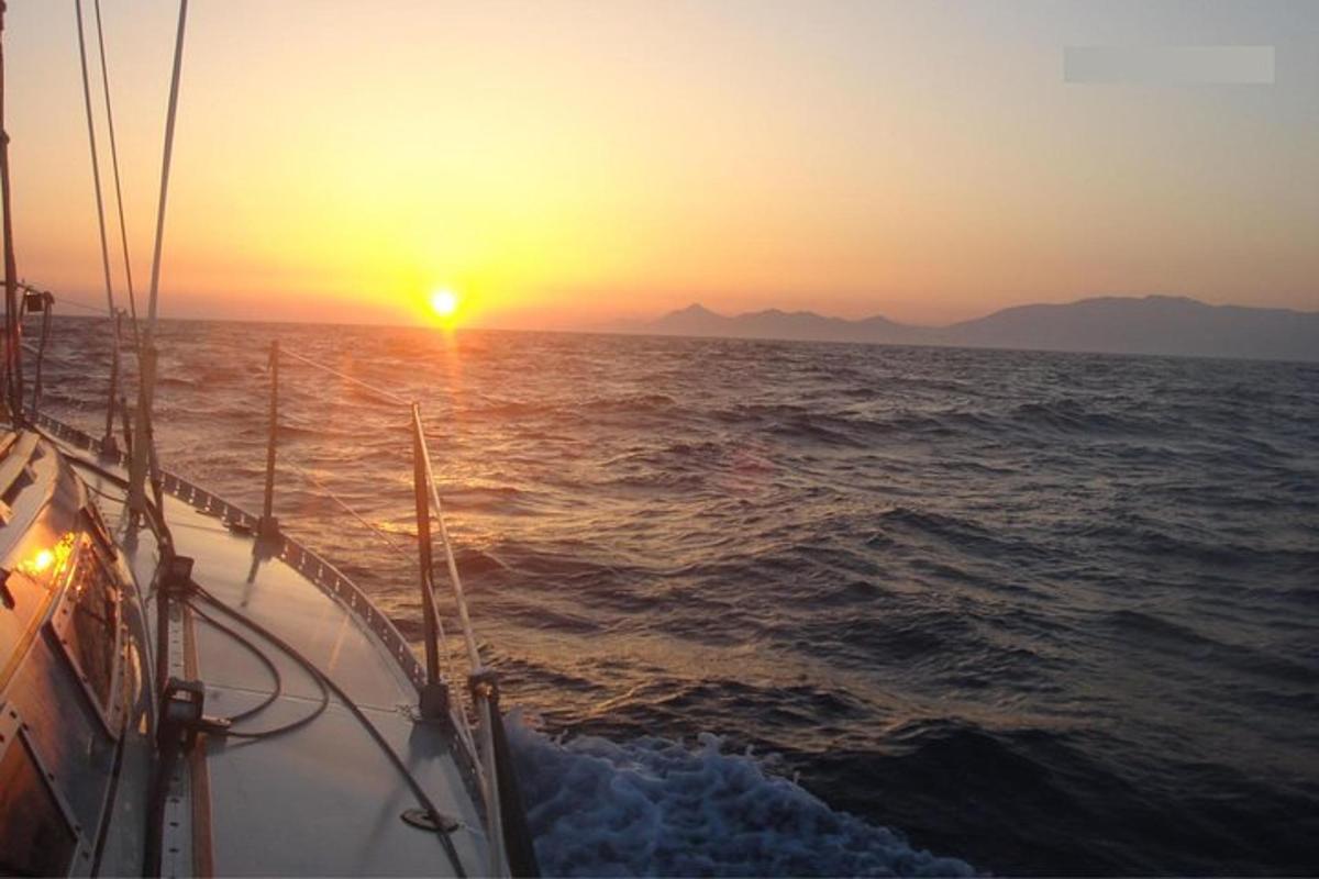 μια βάρκα στον ωκεανό καθώς δύει ο ήλιος