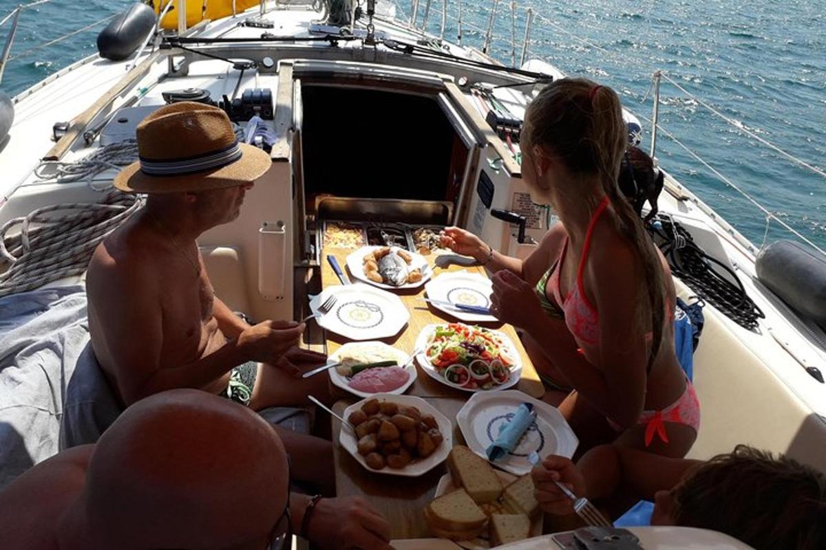 μια ομάδα ανθρώπων που κάθονται γύρω από ένα τραπέζι σε μια βάρκα
