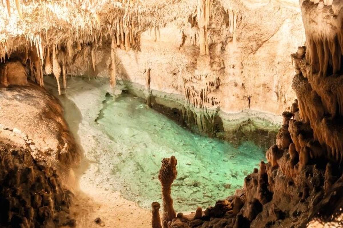 a cave with a pool of green water in it