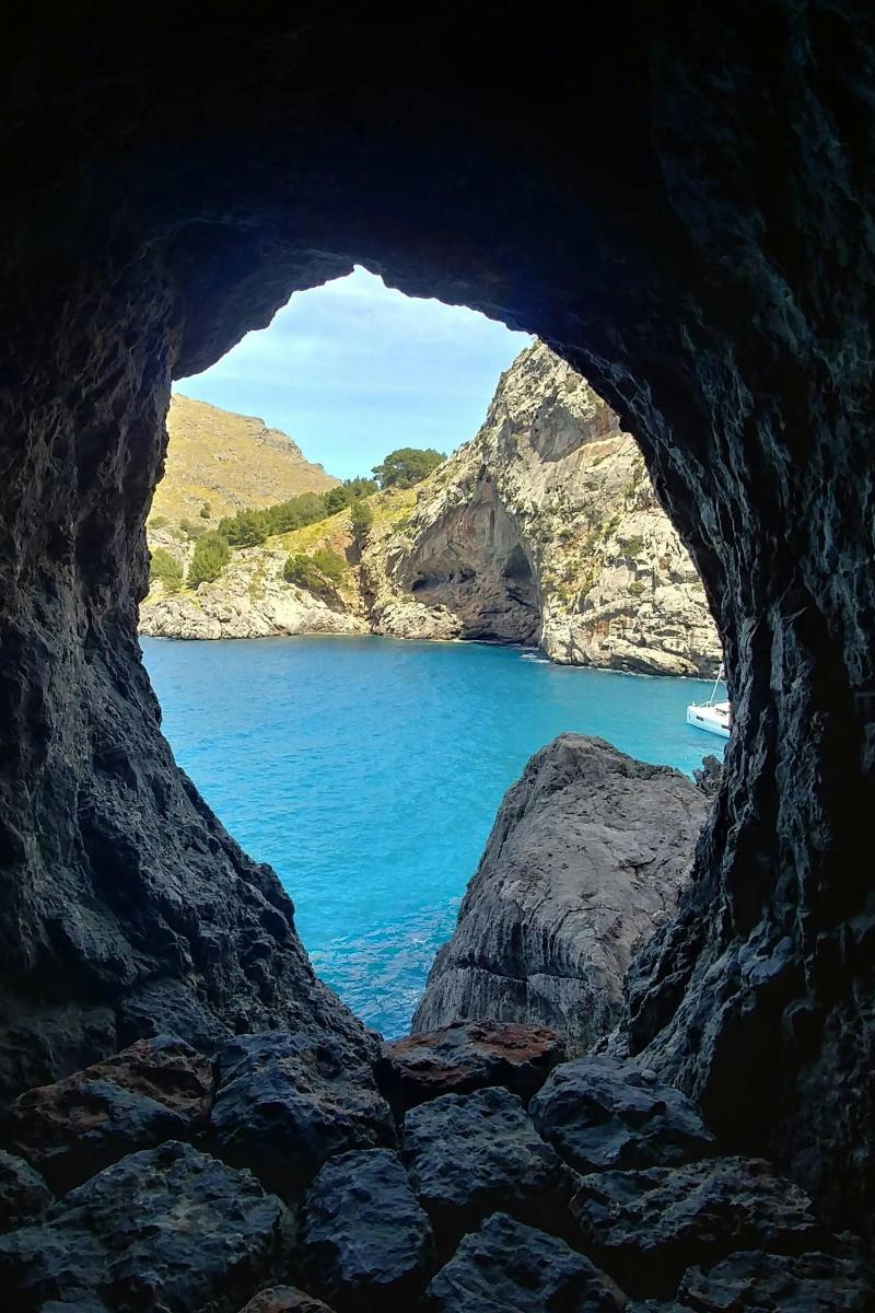 a cave with a view of a body of water