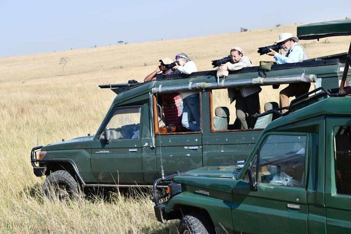 a group of people taking pictures on the roof of a green truck