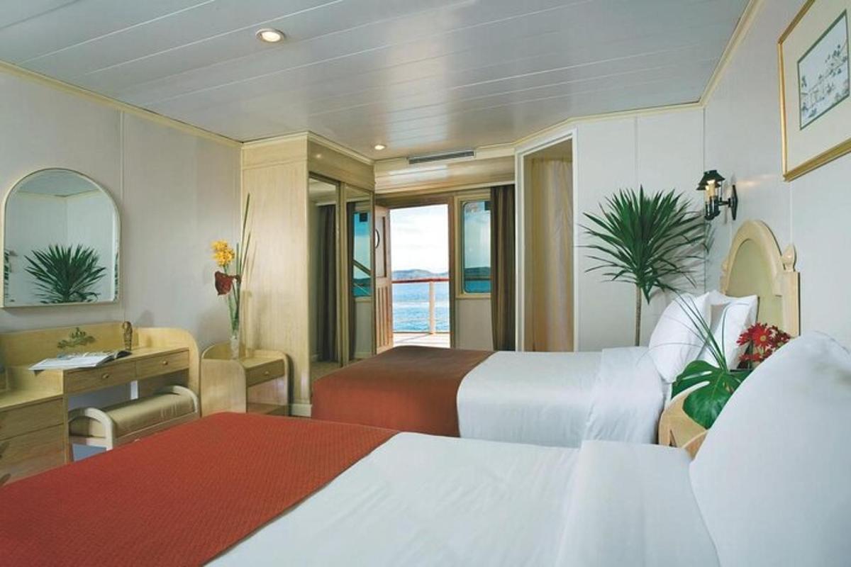 et hotellrom med to senger, et skrivebord og et bad