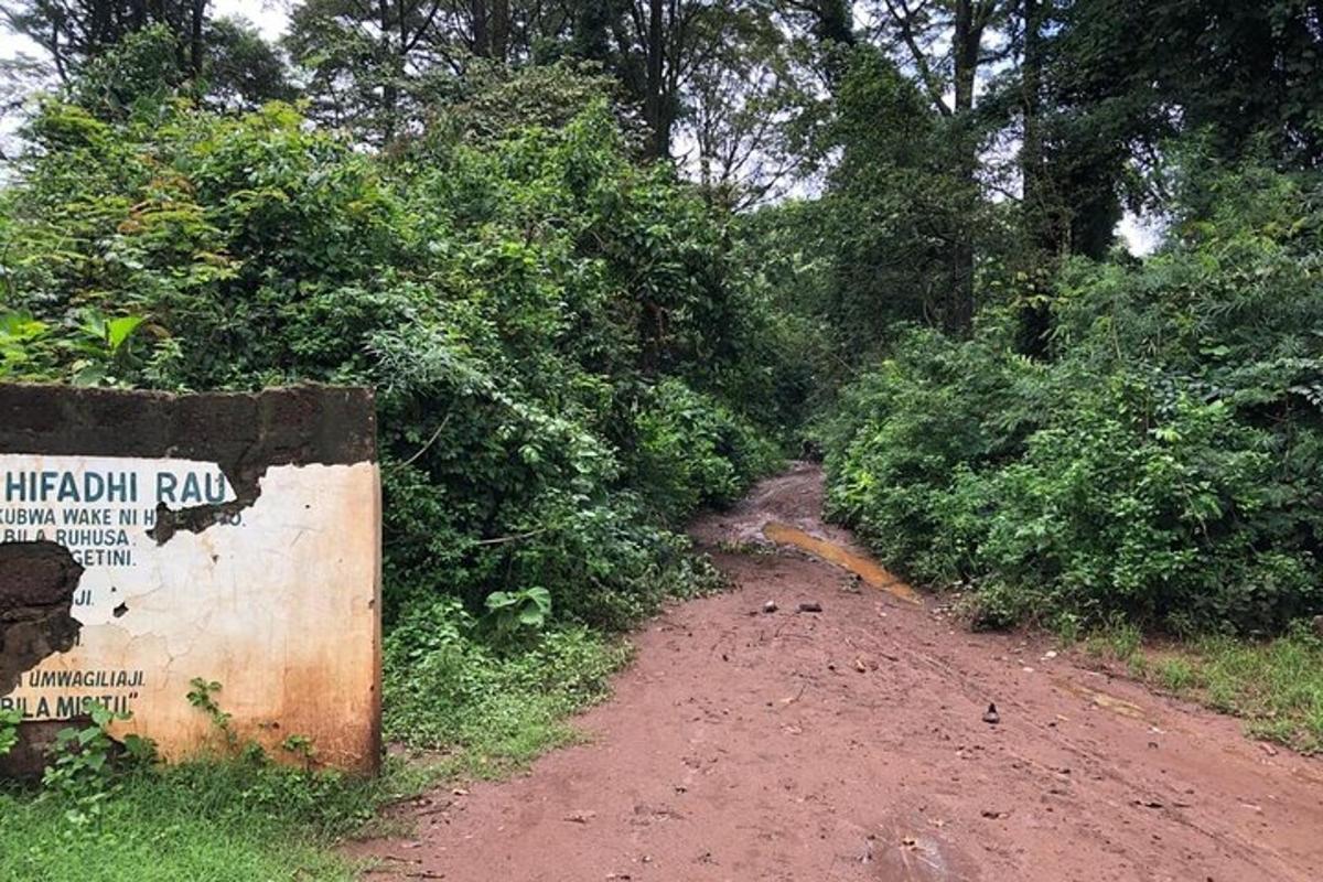 uma estrada de terra com uma placa na lateral