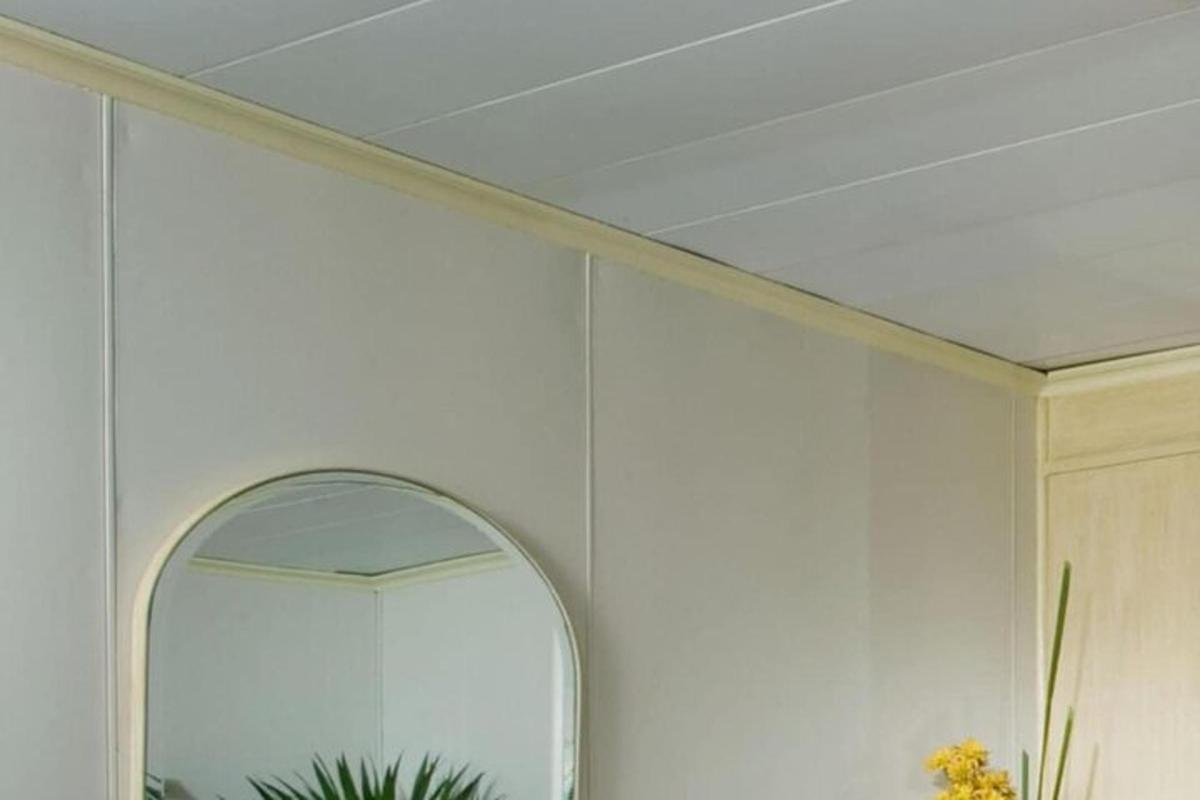 una stanza bianca con uno specchio e un soffitto