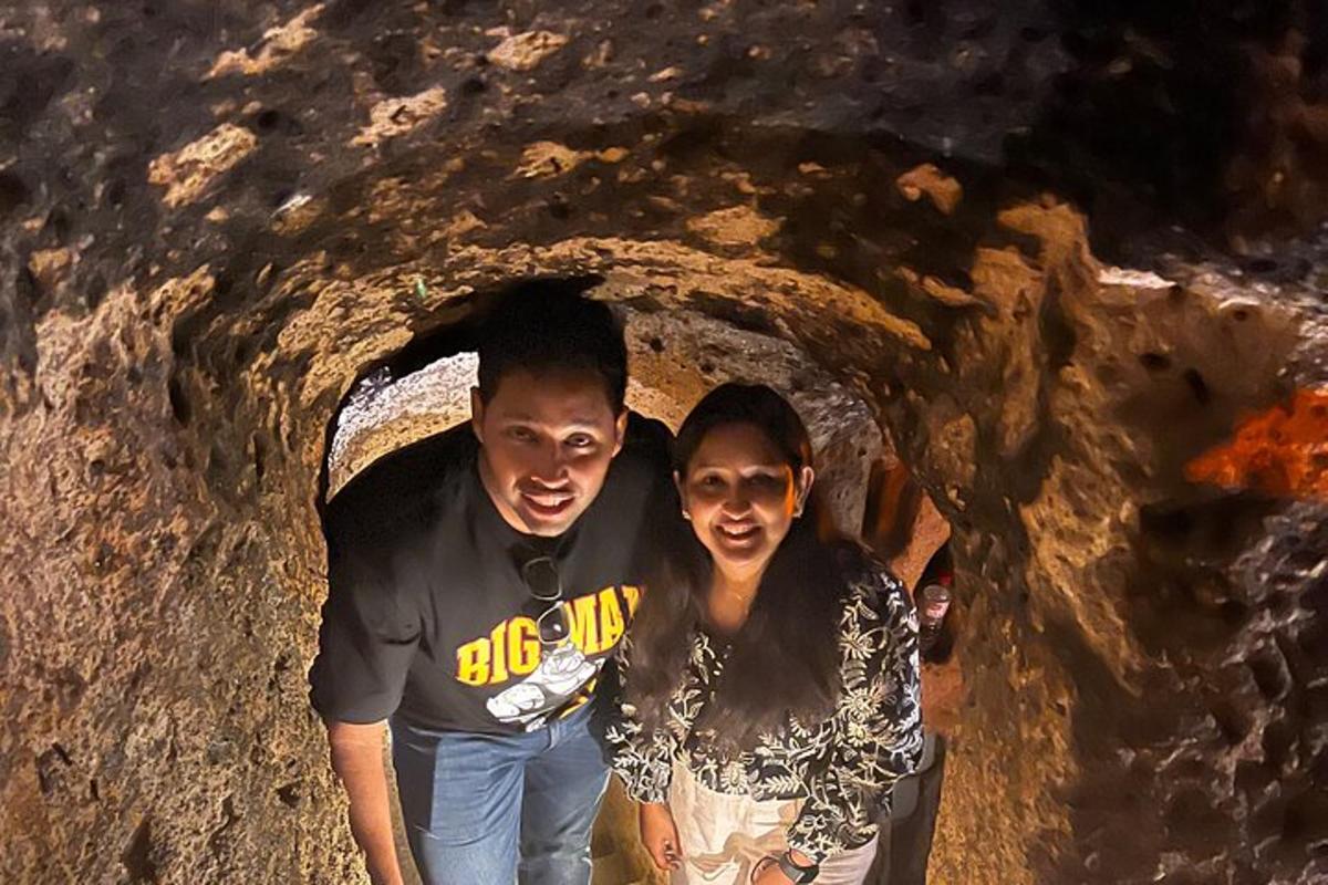 um homem e uma mulher caminhando por uma caverna
