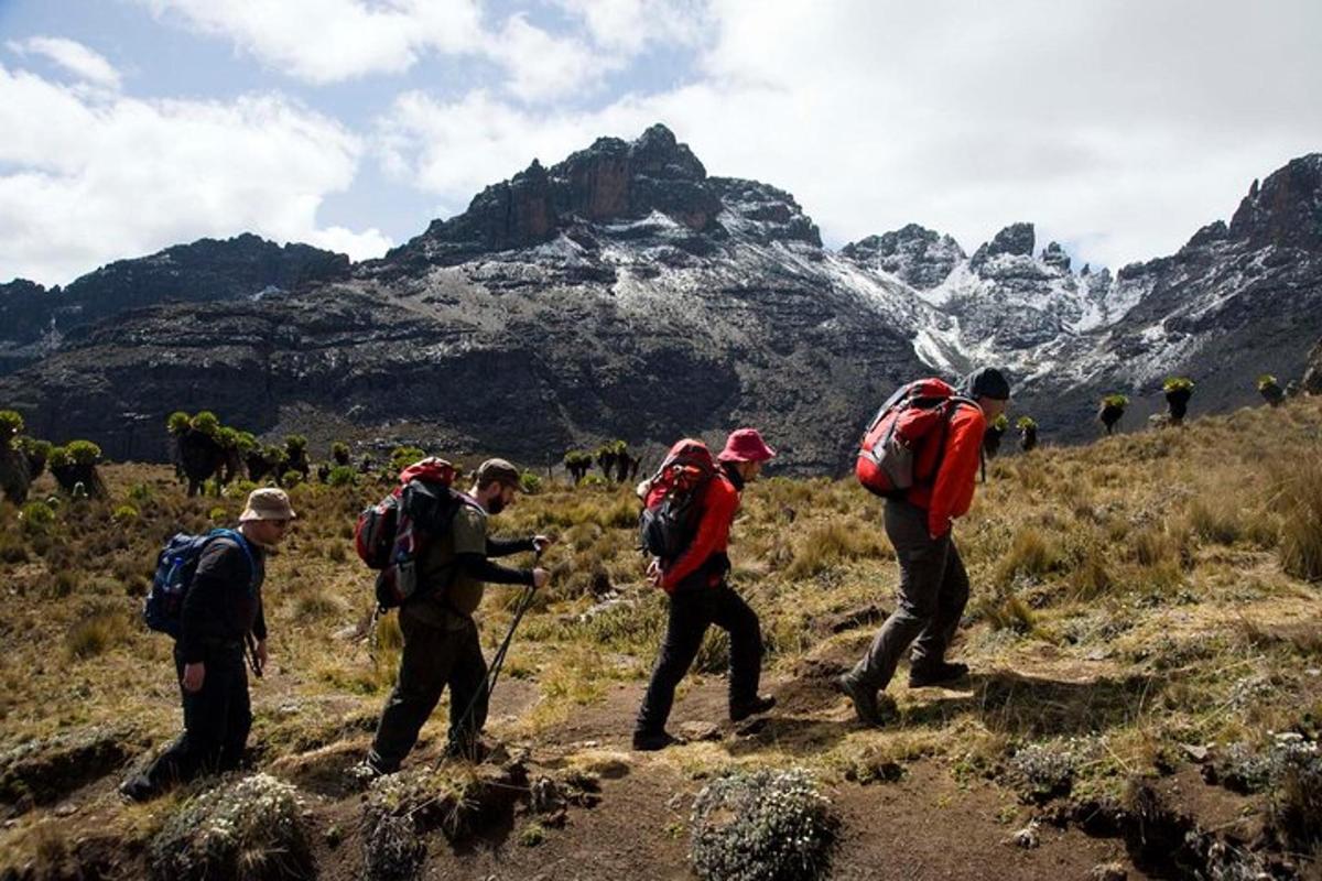 sekumpulan orang dengan beg galas berjalan di atas gunung