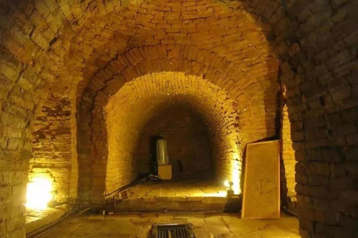 un vecchio tunnel di mattoni con una lampada al suo interno