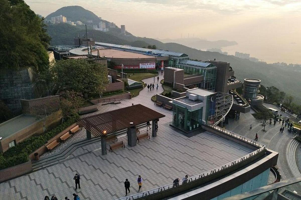 un gruppo di persone che camminano intorno a un edificio con le montagne sullo sfondo