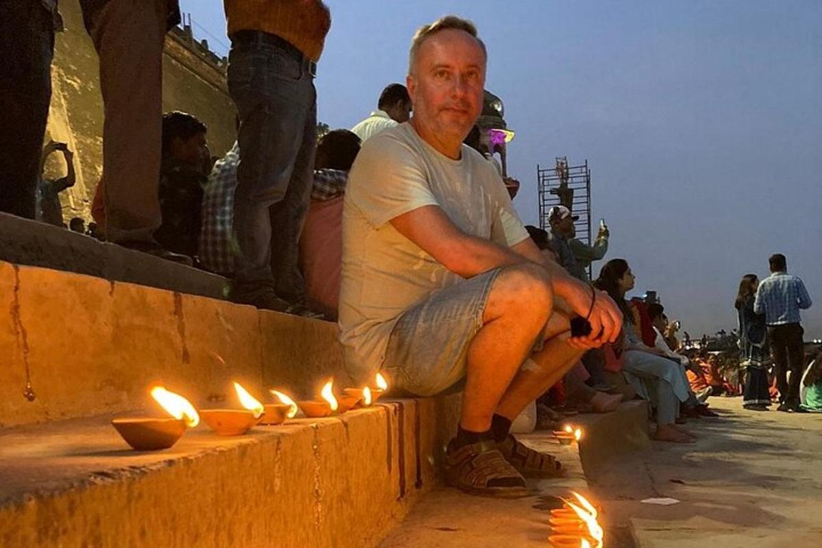 a man sitting on a ledge with lit candles