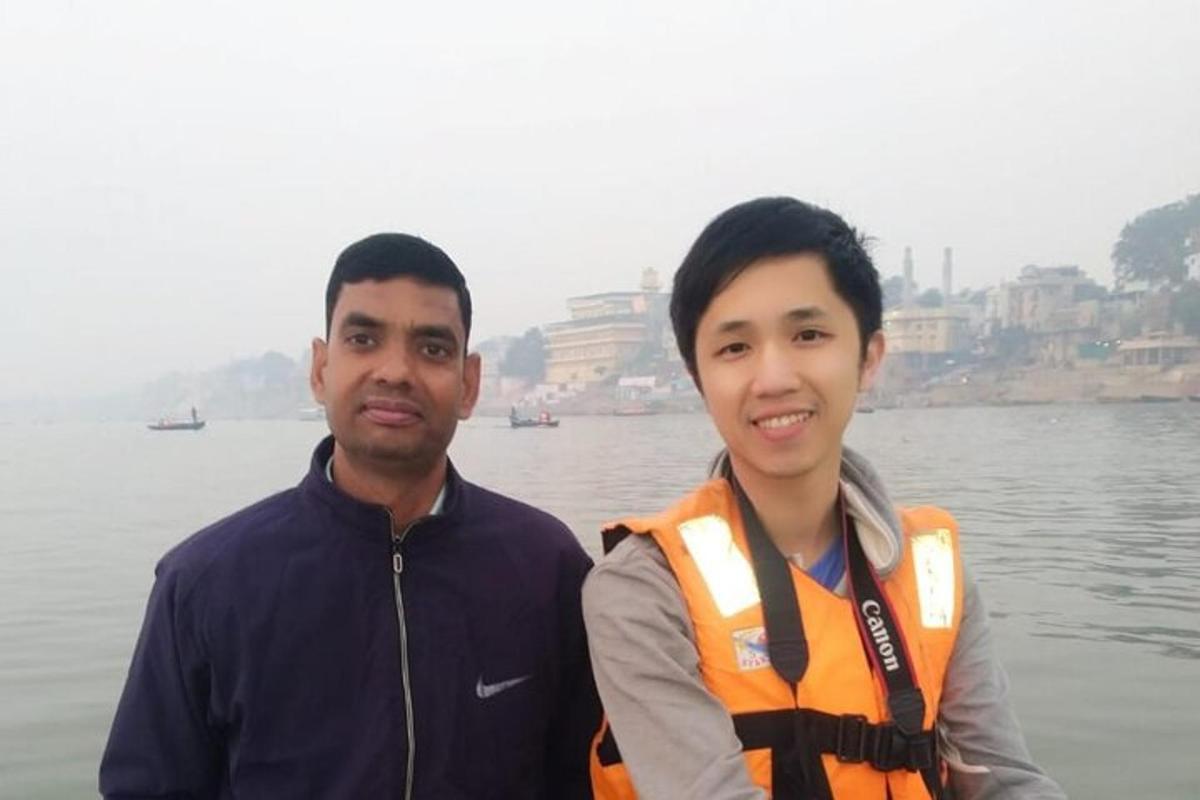 dua pria berdiri di samping badan air