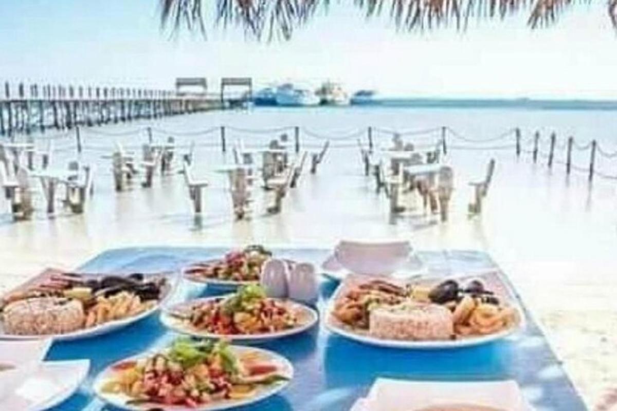una mesa con platos de comida en una playa
