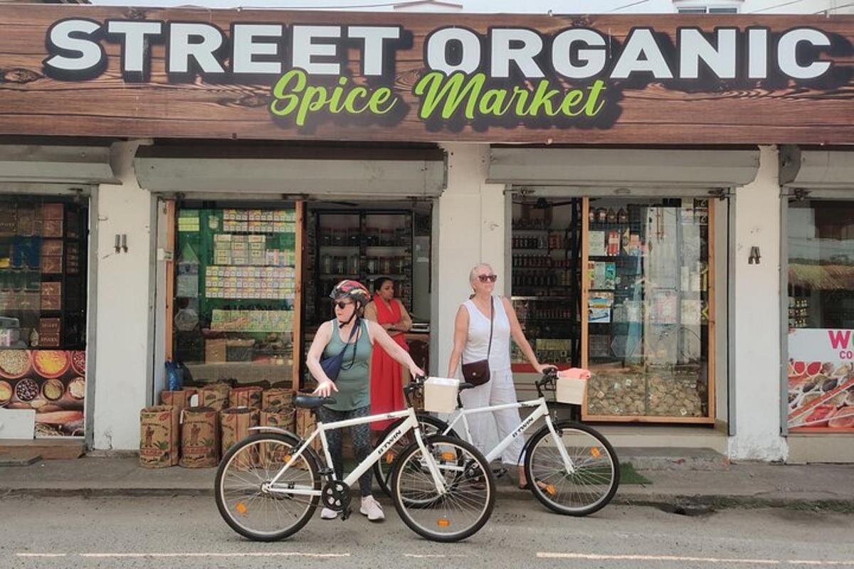 two people standing with their bikes in front of a store