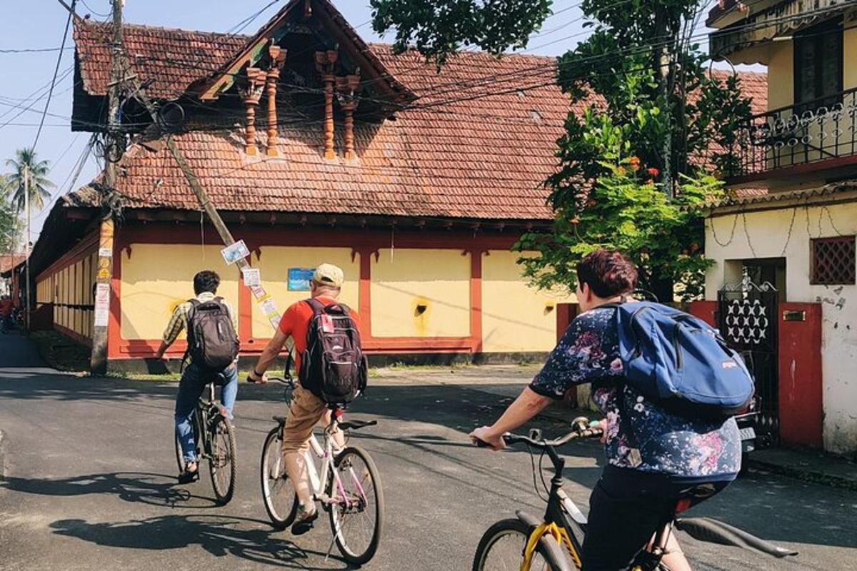 three people riding bikes down a street